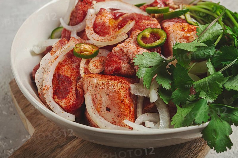Raw meat marinated with spices and onions, for barbecue, sliced meat, pork neck, in a bowl, homemade, no people