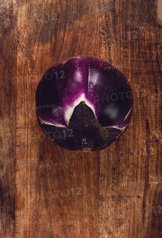 Purple and white eggplant, spherical shape, on a wooden board, top view, raw eggplant, no people