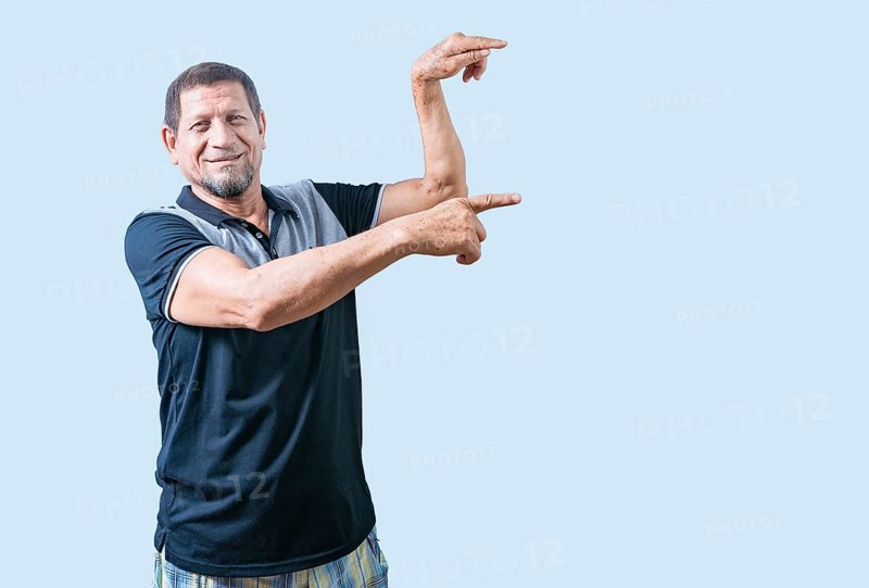 Happy senior man pointing at an advertising space isolated. Smiling senior man pointing to the side isolated