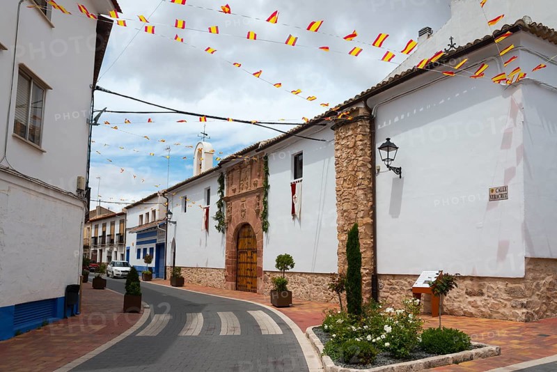 A decorated street with Spanish flags and white-painted houses, Ermita de la Vera Cruz, hermitage, Campo de Criptana, Ciudad Real province, Castilla-La Mancha, Route of Don Quixote, Spain, Europe