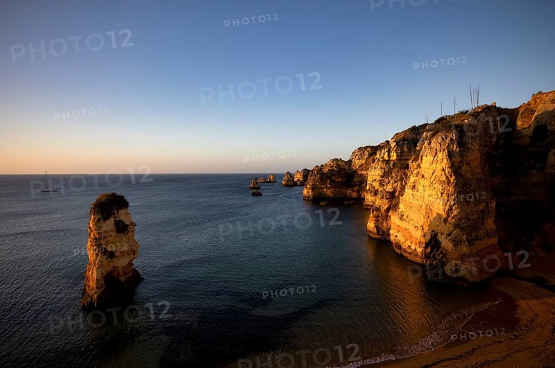 Sailing ship, coloured cliffs and rocks at sunrise on the beach, Praia da Dona Ana, Lagos, cliffs, Atlantic Ocean, Algarve, Portugal, Europe