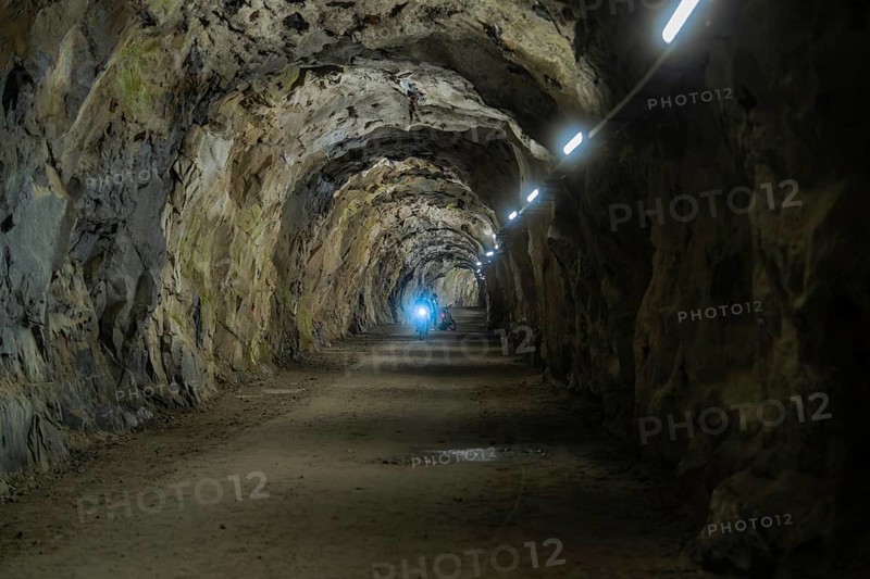 Dark tunnel with illuminated stone walls and a mysterious atmosphere, Klein Tibet, Zillertal, Austria, Europe