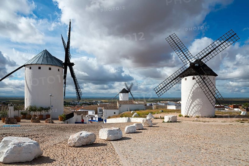Three windmills in a village under a cloudy sky, Campo de Criptana, Ciudad Real province, Castilla-La Mancha, Don Quixote Route, Spain, Europe