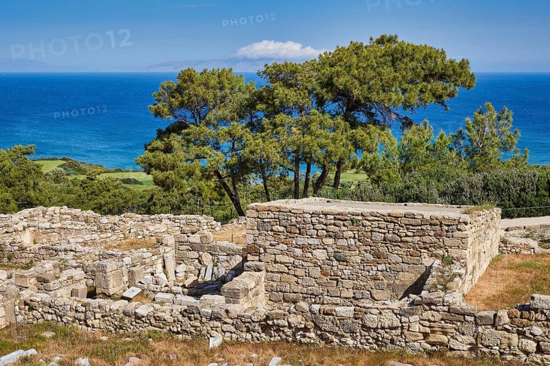 Ancient wall remains near a coast, surrounded by trees and a clear blue sky, the sea in the background, Kamiros, Archaeological site, Ancient city, Foundation of Doric Greeks, Rhodes, Dodecanese, Greek Islands, Greece, Europe