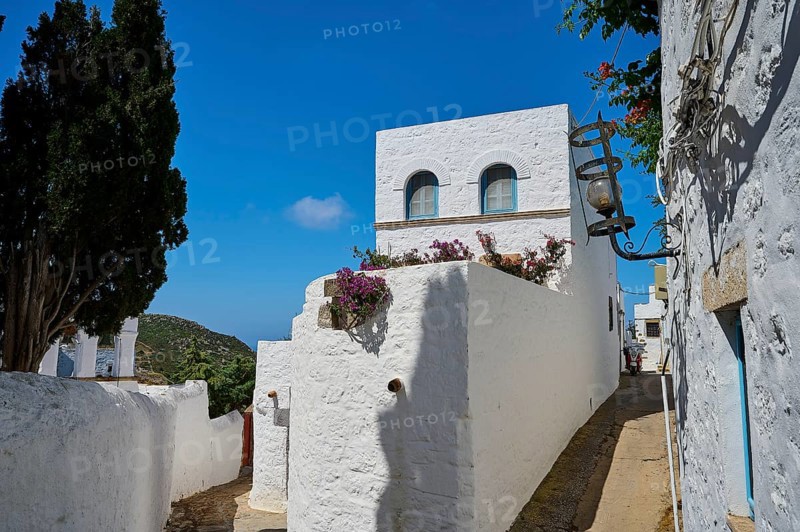 White, Mediterranean houses with blue sky, flowers on the balcony, sunny narrow alley, Chora, main town Patmos, Patmos, old town, Dodecanese, Greek Islands, Greece, Europe