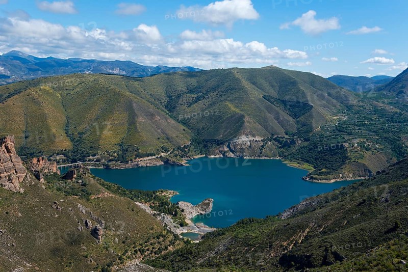 Large blue lake, surrounded by green mountains and hills, under a cloudy sky, reservoir, Embalse de Canales, Canales dam, Sierra Nevada, near Güéjar Sierra, Granada province, Andalusia, Spain, Europe