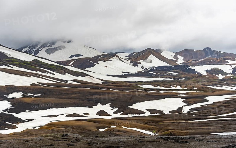 Dramatic volcanic landscape with mountains and snow, at Höskuldsskáli hut in Hrafntinnusker, Laugavegur trekking trail, Landmannalaugar, Fjallabak Nature Reserve, Suðurland, Iceland, Europe