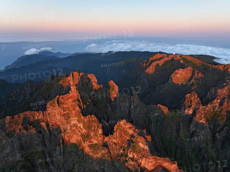 Aerial drone view of Pico do Arieiro and mountains over clouds on sunset. Above Pico Ruivo, Madeira island, Portugal, Europe