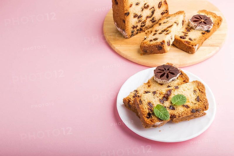 Homemade cake with raisins and dried persimmon on a pink pastel background. Side view, close up, copy space
