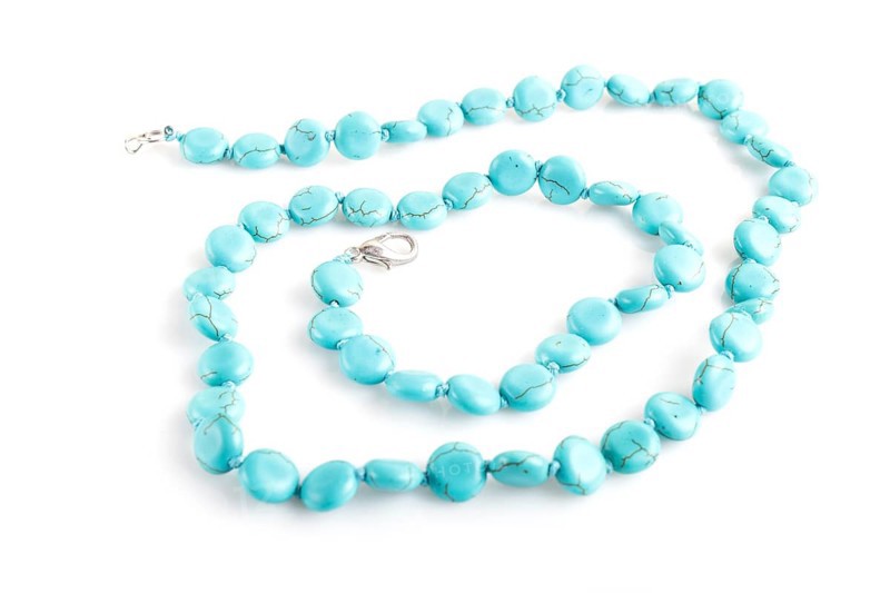 Blue semiprecious stone beads isolated on white background. top view, close up