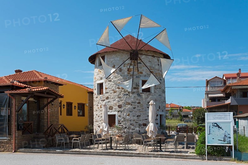 A converted windmill into a restaurant with outdoor seating under a clear blue sky, Ierissos, Sithonia, Halkidiki, Central Macedonia, Greece, Europe