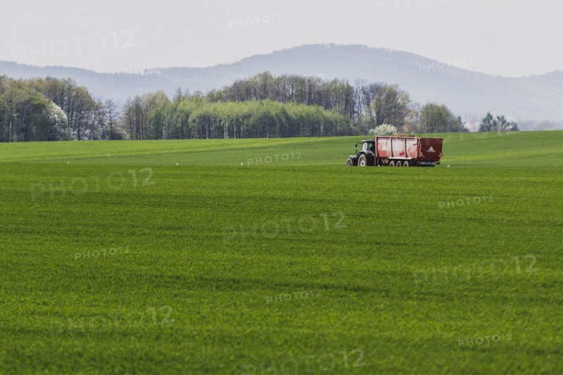 A tractor on a country road stands out in front of a field in Vierkirchen, 12.04.2024