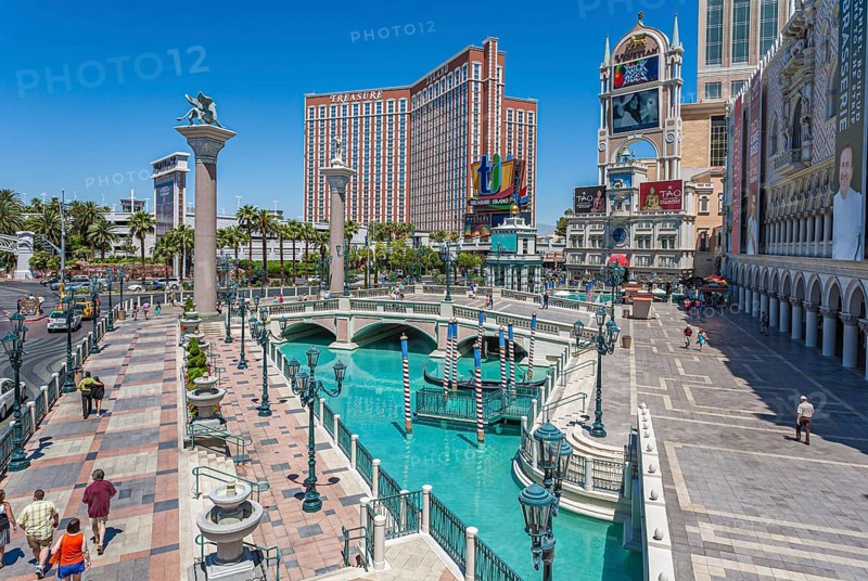 Treasure Island hotel and casino rises up beyond the pools of the Venetian resort on the Las Vegas Strip in Paradise, Nevada, USA, North America