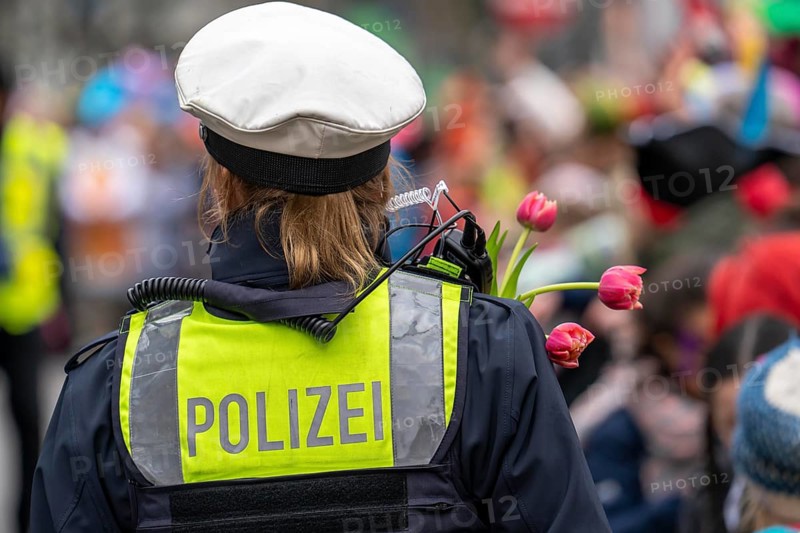 Rose Monday parade in Düsseldorf, policemen on duty at the street carnival, with flower decorations, given by the parade participants, North Rhine-Westphalia, Germany, Europe