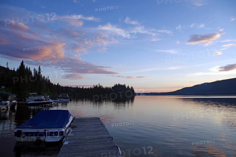 A calm lake at sunset, a jetty with boats and idyllic nature in the background, St. George, British Columbia, Canada, North America