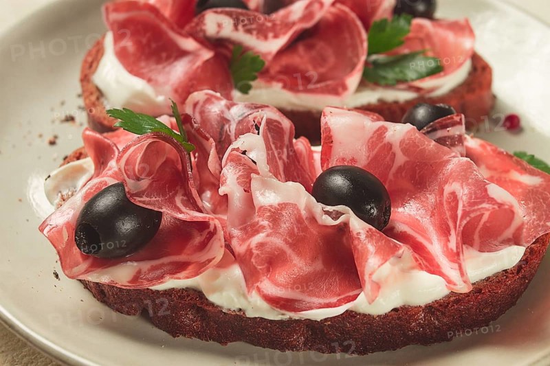 Sandwich with cream cheese, prosciutto with olives, breakfast