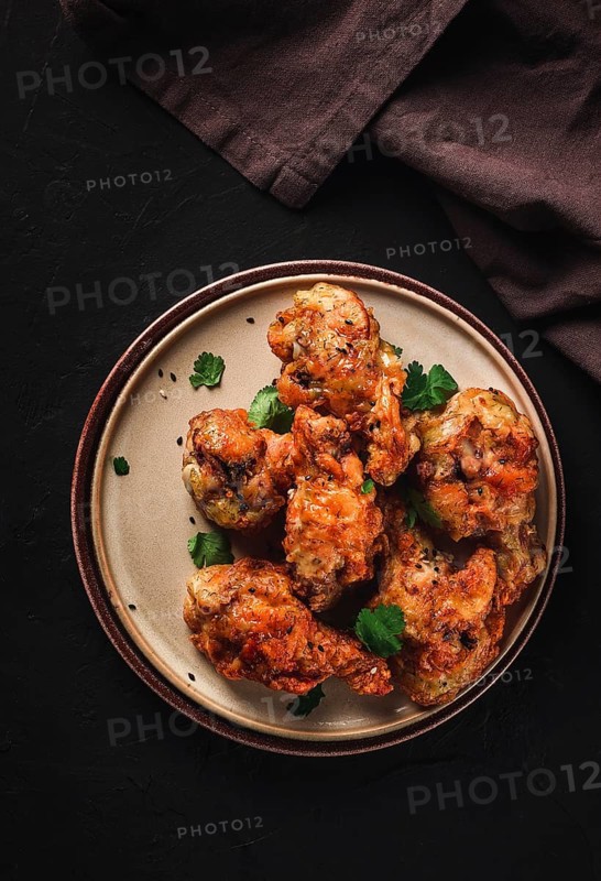 Fried chicken legs, breaded, with spices and herbs, on a dark background, vertical, no people, selective focus, toned