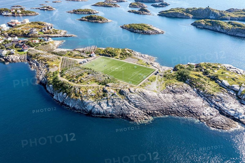 Aerial view over football stadium on rocky island, fishing village Henningsvaer, Lofoten, Norway, Europe