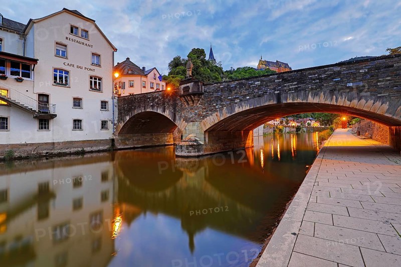 Town view of Vianden with the old stone bridge over the river Our and the castle in the evening, Grand Duchy of Luxembourg