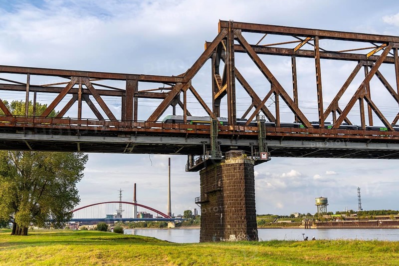 The railway bridge Duisburg-Hochfeld-Rheinhausen, over the Rhine, regional trains and many goods trains cross the Rhine here, from 1950, steel truss bridge, in the background the Bridge of Solidarity in DU-Rheinhausen, road bridge, Duisburg, North Rhine-Westphalia, Germany, Europe