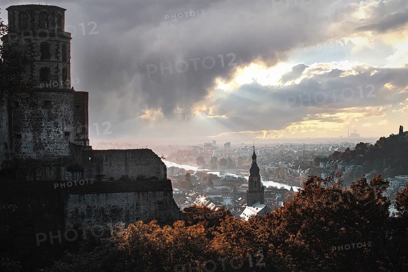 Romantic view of the city of Heidelberg with river and castle under a dramatic sky and falling light, Heidelberg, Germany, Europe