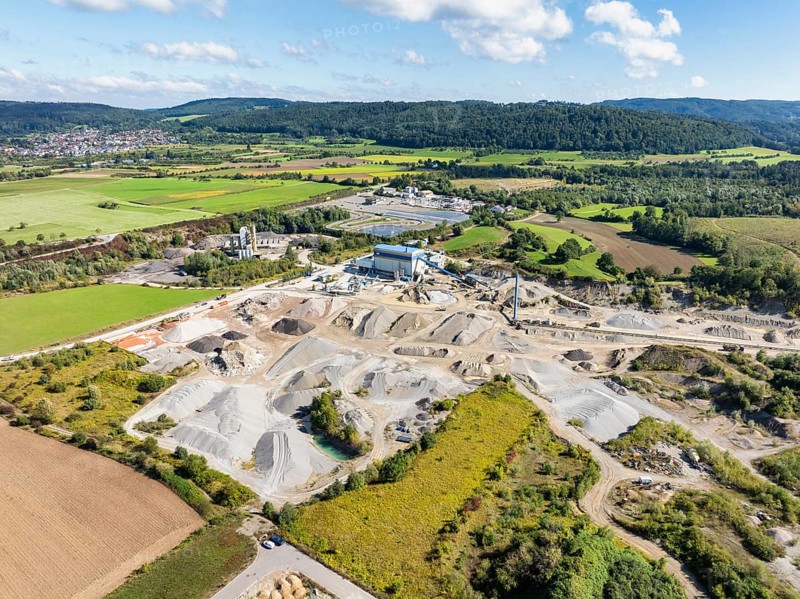 Aerial view of a gravel pit, gravel extraction area, gravel works, ADAC driving safety centre, asphalt mixing plant and building materials warehouse in the Steißlingen industrial estate and business park, Hegau, Constance district