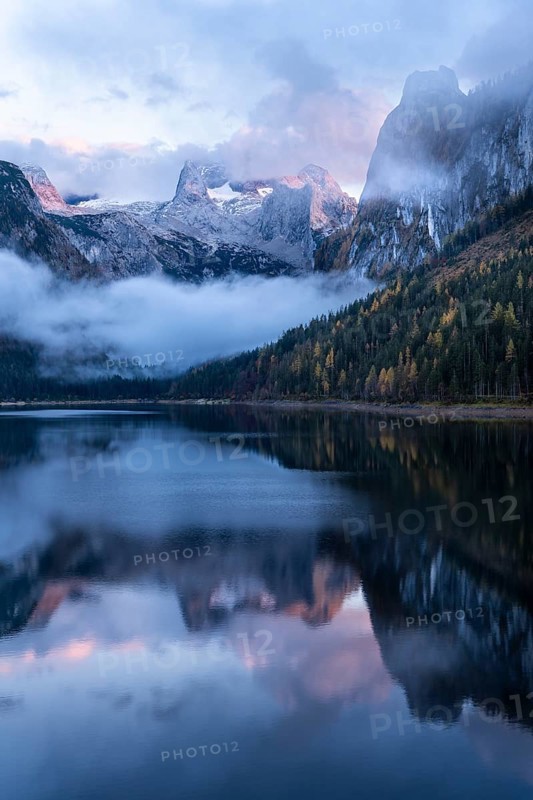 The Vordere Gosausee lake in autumn with a view of the Dachstein mountain range. The Gosaukamm on the right. Blue sky and clouds. In the evening at sunset. Reflection. Vorderer Gosausee, Gosau, Gosau valley, Salzkammergut, Upper Austria, Austria, Europe