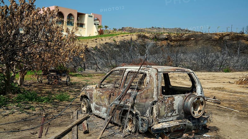 Burnt car in a landscape destroyed by a fire, buildings and dry trees in the background, forest fires, summer 2023, forest fire damage, Boutique 5 Hotel, Kiotari, Rhodes, Dodecanese, Greek Islands, Greece, Europe