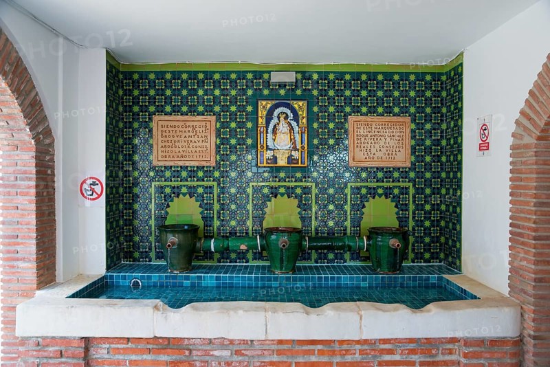 A decorated interior with blue mosaic and several taps, adorned with religious symbols and Spanish inscriptions, Fuente del Pilar Grande, Canillas de Aceituno, Málaga province, Malaga, Andalusia, Spain, Europe
