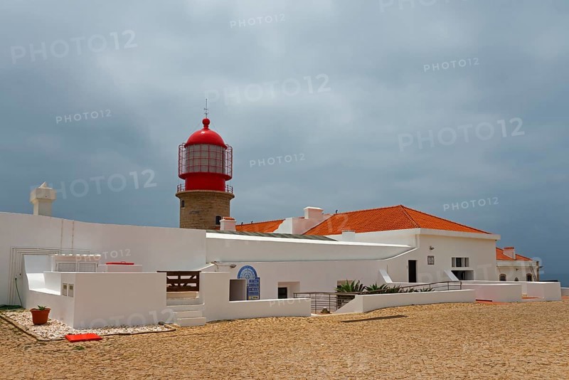 A white building with a red lighthouse under a cloudy sky, Cape St Vincent, Cape St Vincent, Cabo de São Vicente, south-westernmost point of the European mainland, Sagres, Algarve, Portugal, Europe