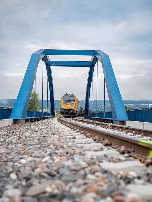 Railway train crossing a blue bridge on a cloudy day, track construction, rail delivery for Hermann Hessebahn, Calw, Black Forest, Germany, Europe
