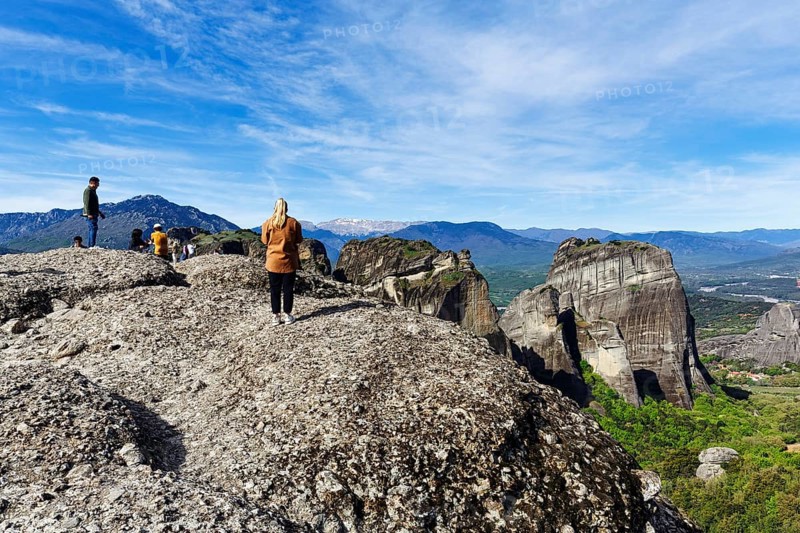 Group of tourists on rocks, enjoying the view, Meteora Trail, blue sky, Thessaly, Greece, Europe