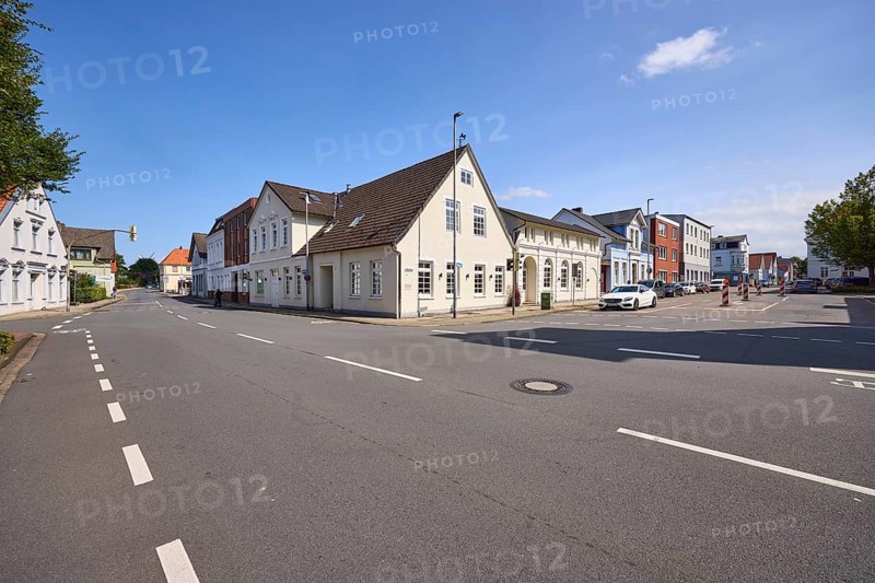 Junction of Nebbsallee and Mühlenstraße with road and cycle path as well as two-storey buildings with pointed roofs in Varel, district of Friesland, Lower Saxony, Germany, Europe