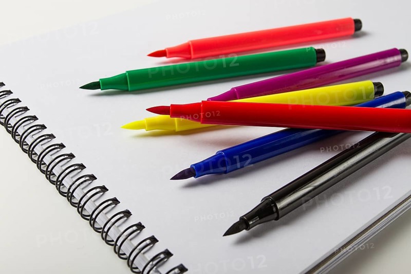 Watercolor pens brush, assortment, on a drawing album, artist's desk, top view, close-up, selective focus