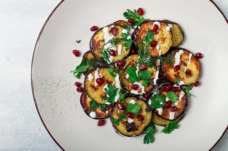 Fried eggplant, with white sauce, pomegranate seeds, top view, no people