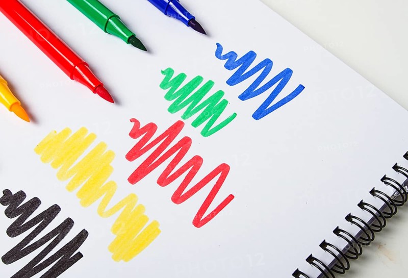 Watercolor pens brush, assortment, on a drawing album, artist's desk, top view, close-up, selective focus