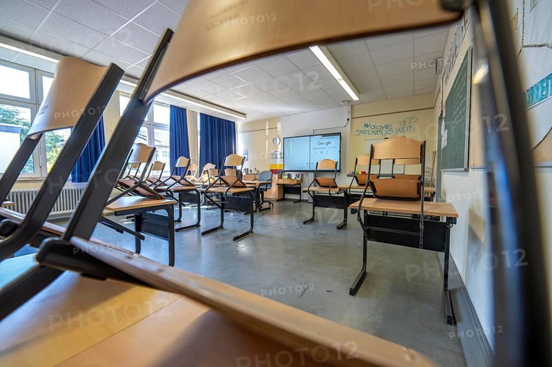 Classroom of a fourth grade, after school, the building is older but in good condition, modern teaching materials, interactive, digital whiteboard