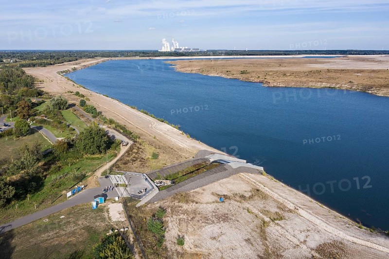 View from the Baltic Sea to the Jänschwalde lignite-fired power plant of LEAG Lausitz Energie Kraftwerke AG. The Cottbus Baltic Sea is a project in which the former Cottbus-Nord opencast lignite mine is flooded with water from the River Spree, Lakoma, 02/10/2021