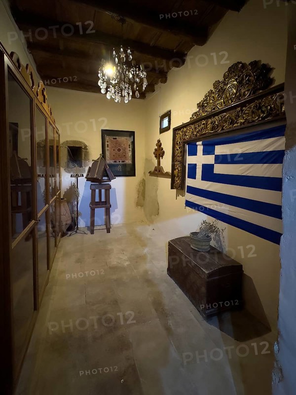 Chamber room with festive chandelier chandelier right Greek national flag flag of Greece in Xopatera Tower Tower of Xopateras from 19th century in Unesco Site Site Orthodox Greek Orthodox Monastery Moni Odigitria, Festos, Crete, Greece, Europe