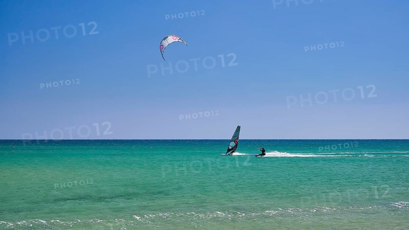A person windsurfing in a clear blue sea under a sunny sky, surfers paradise, kitesurfer, windsurfer, Prasonisi, island in the south of Rhodes, Rhodes, Dodecanese, Greek Islands, Greece, Europe