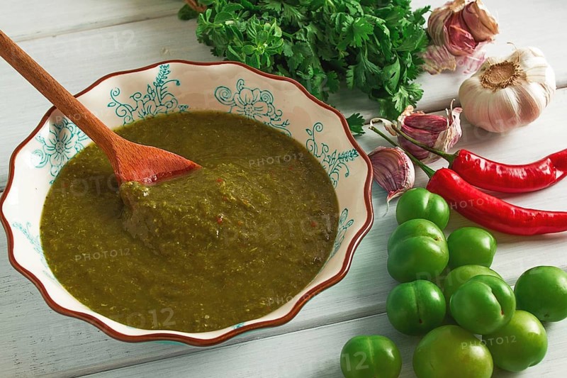 Tkemali sauce, traditional Georgian cuisine, green cherry plum, with ingredients for sauce, cilantro, mint, hot pepper, garlic, on a white wooden table, close-up, rustic, food background, no people, selective focus, sauce, green sauce, tkemali, georgian cuisine, homemade