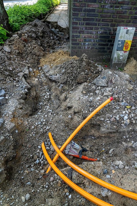 Laying of fibre optic cables, empty conduits are laid under a pavement, in which the actual fibre optic cable is later blown in and connected to the respective house connection or distributor. Essen, North Rhine-Westphalia, Germany, Europe