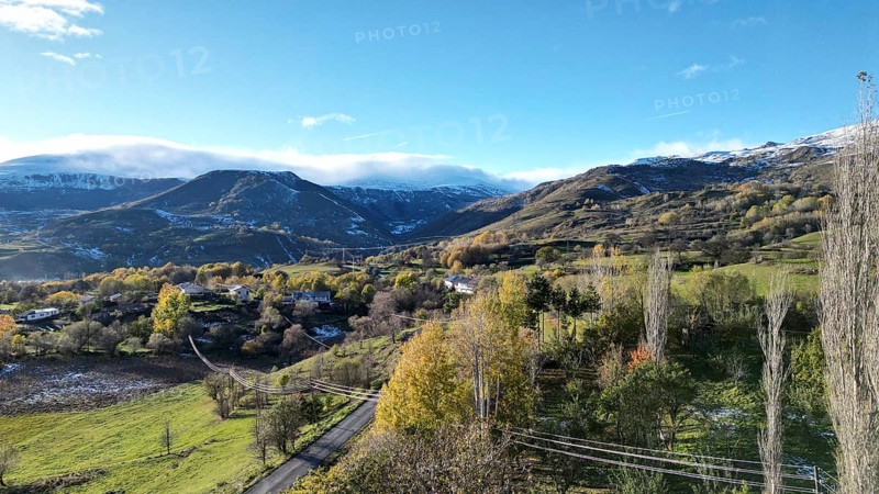 A scenic valley with mountains, scattered trees, and a clear blue sky, capturing a serene winter atmosphere. Posof, Ardahan, TURKEY