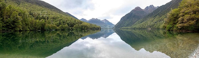 Tranquil lake Gunn in Fiordland National Park, landscape reflecting on the water surface, South Island of New Zealand