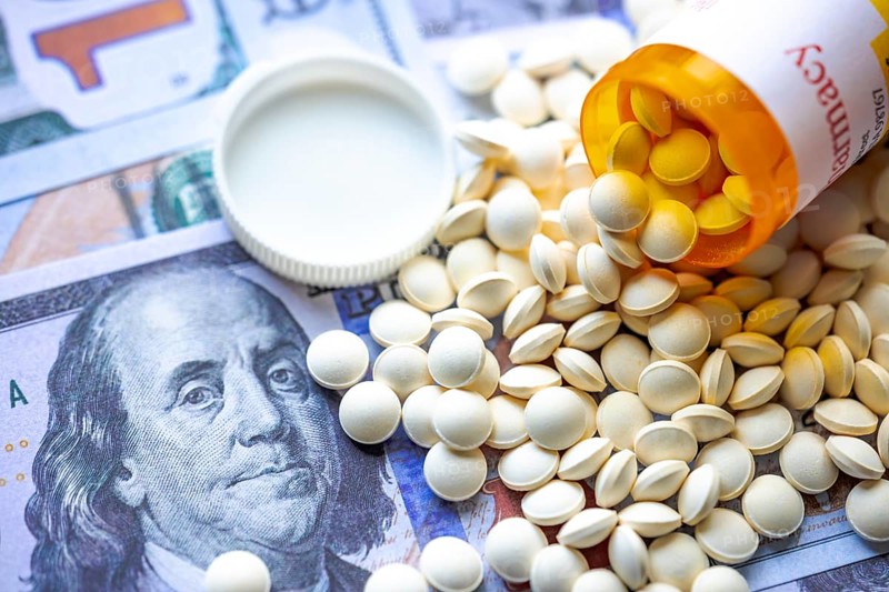 An open medicine pill container on American bills. Concept: American opioid crisis or American health care crisis