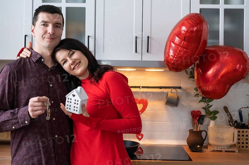 Man and woman in love date at home in kitchen with keys of house. Valentine's Day, happy couple, love story. Love nest, mortgage, relocation, purchase, real estate, housing for young family