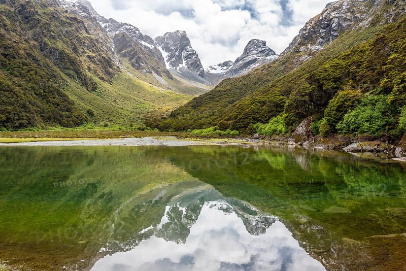 Tranquil mountain lake Mackenzie at the famous Routeburn Track, Fiordland National Park, South Island of New Zealand