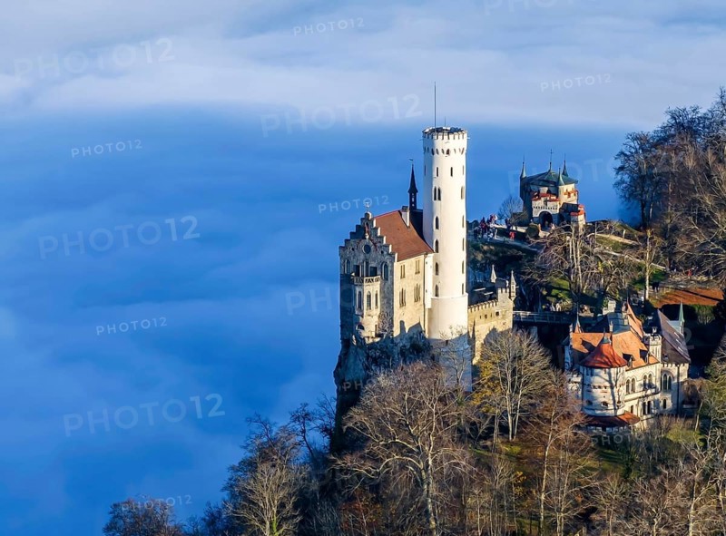 Sunshine in the mountains, fog in the Echaz valley. Lichtenstein Castle in the Swabian Alb. The fairytale castle of Württemberg is a 19th century castle built in the historicist style. Aerial photo. Lichtenstein, Baden-Württemberg, Germany, Europe