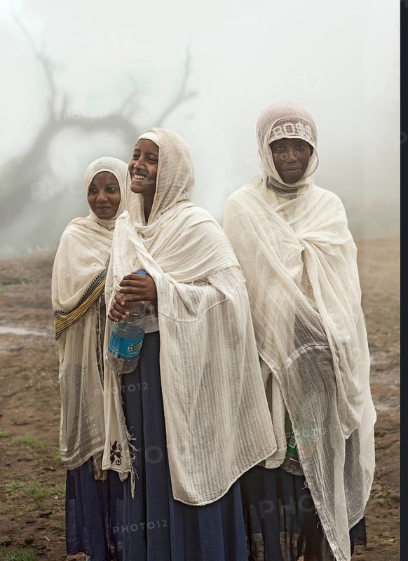 Three young Ethiopian pilgrims have arrived in the pilgrimage site of Lalibela after a long pilgrimage, Lalibela, Ethiopia, Africa
