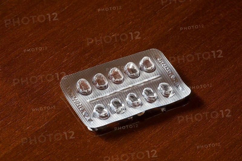 Empty blister packaging on a brown wooden surface